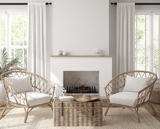 Landelijk interieur witte houten jaloezieën en gordijnen combineren rotan stoelen rieten kist open haard wit interieur