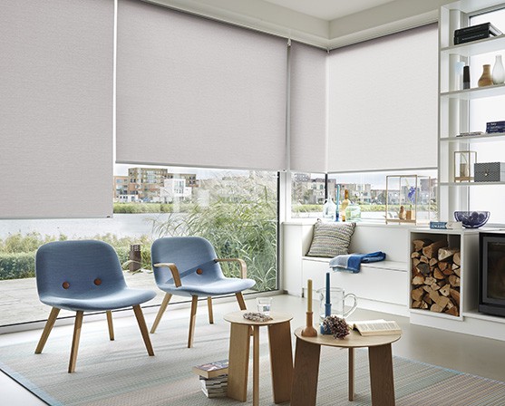 Scandinavische raambekleding rolgordijnen woonkamer scandinavische stijl blauwe stoelen hout minimalistisch interieur